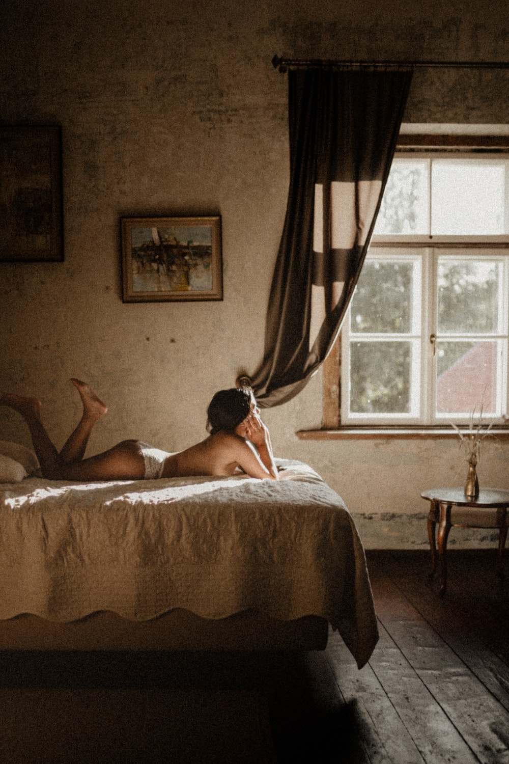 Foto vintage de chica en cama mirando hacia la ventana
